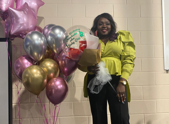 a woman smiling holding balloons