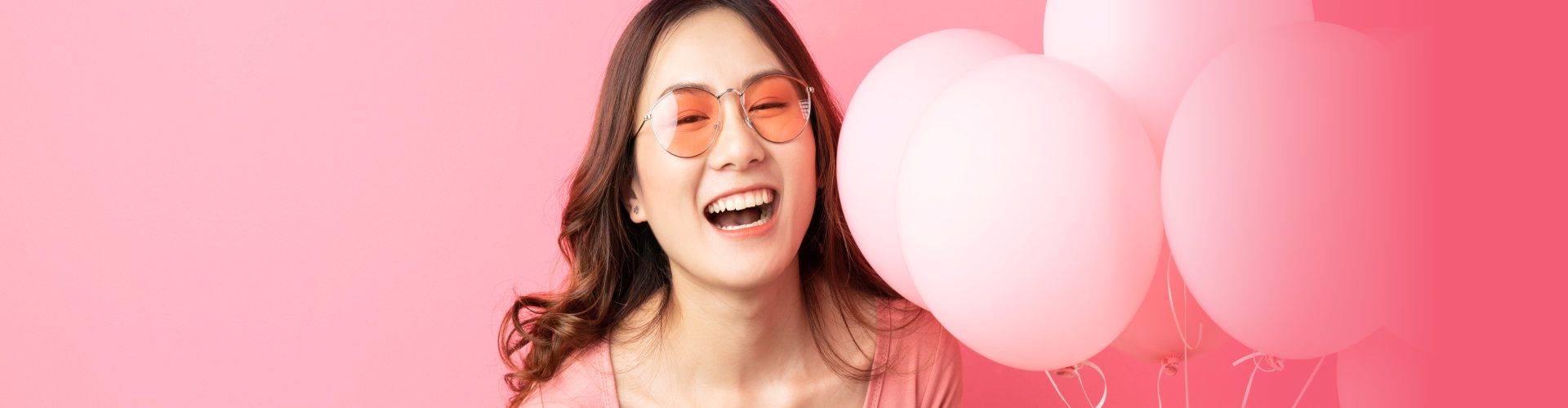 girl laughing holding balloons